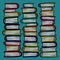 Three hand drawn stacks of colorful books on teal background