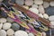 Three handmade homemade colorful natural woven bracelets of friendship river stones background