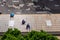 Three handyman workers repairing tiles on the damaged factory roof