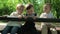 Three happy children sitting on a bench in the park