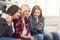 Three happy female friends using smartphones