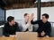 Three happy freelance men working together in co-working space