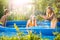 Three happy friends playing in the inflatable pool