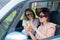 Three happy girlfriends go on a trip. Women are driving in a car and taking a selfie on a mobile phone