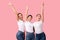 Three Happy Girls Gesturing V-Sign Having Fun On Pink Background