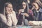 Three happy girls playing board game.