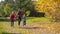 Three happy kids running together in autumn forest