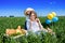 Three happy kids sitting on picnic on the field. blue sky, green grass. bread, pies and fruits in a basket.