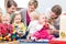 Three happy mothers watching their babies playing with safe toys