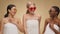 Three happy multiethnic ladies wrapped in towels and wearing sunglasses looking at each other and laughing