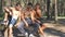 Three happy muscular athletes sitting at the forest and looking pictures at the smartphone. Cheerful friends watching