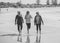 Three happy senior women walking and exercising together on beach. Retirement and healthy lifestyle