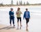 Three happy senior women walking and exercising together on beach. Retirement and healthy lifestyle