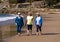 Three happy senior women walking and exercising together on beach. Retirement and healthy lifestyle