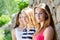 Three happy teenage girl friends smiling at stone wall background on summer day