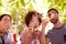 Three happy young friends blowing bubbles