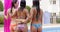 Three happy young women in bikinis