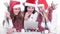 Three happy young women in costumes of Santa Claus looking at t