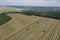 Three harvesters harvest ripe golden wheat in a grain field. Agricultural work in summer. John Deere green yellow combine