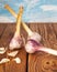 Three heads of freshly harvested garlic and peeled cloves lie on a table