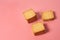 Three heaps of whole square cookies lies on pink desk on kitchen