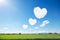 three heart shaped clouds on blue sky and sunshine above rice field