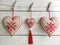 Three heart wall hanging from linen with red embroidery and tassel