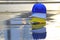 Three helmets yellow, white and blue on concrete floor and water background