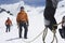 Three hikers joined by safety line in snowy mountains mid section on front man