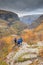 Three hiking persons looking out in the valley of the Aurlandsdalen with autumn colours in the mountains
