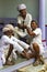 Three Hindu men spend their time sitting in the doorway of the house.