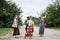 Three hippie women, wearing boho style clothes,, walking on dirt road in countryside, dancing, relaxing, having fun. Friends,