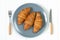 Three homemade baked croissants on plate served with fork and knife top view