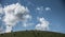 Three horses were grazing under the clouds