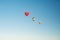 Three hot air balloons in clear blue sky. Aerostat over the field landscape.