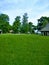 Three houses, fence, green grass and sky