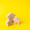 Three houses on a yellow background. Buying and selling of real estate, construction. Apartments and residential buildings