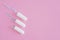 Three hygienic tampons on a pink background.