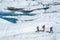 Three ice climbing and trekking guides hiking across the Matanuska Glacier in Alaska