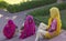 Three Indian ladies in brightly coloured traditional dress sitting on steps