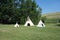 Three indian teepees on a lawn in idaho.
