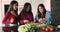 Three Indian women prepare vegetarian dish in the kitchen