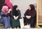 three islamic girls sit in the courtyard of Gazi husrev beg Mosque in Sarajevo