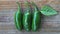 Three JalapeÃ±os on rustic wooden background