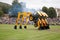 Three JCB loaders suspended on buckets with wheels in the air