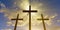 Three Jesus Christ christian crucifixes or crosses backlit from sunset or sunrise sky with glowing rays, god, resurrection, easter