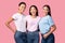 Three Joyful Women Hugging On Pink Background