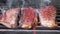 Three juicy and flavorful steaks, roasted on the grill. Marbled beef on a hot grill is cooked on fire. Natural meat cooked in the