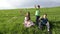 Three kids blowing up the soap bubbles on the hill