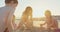 Three kids building sand castles on the beach during sunset